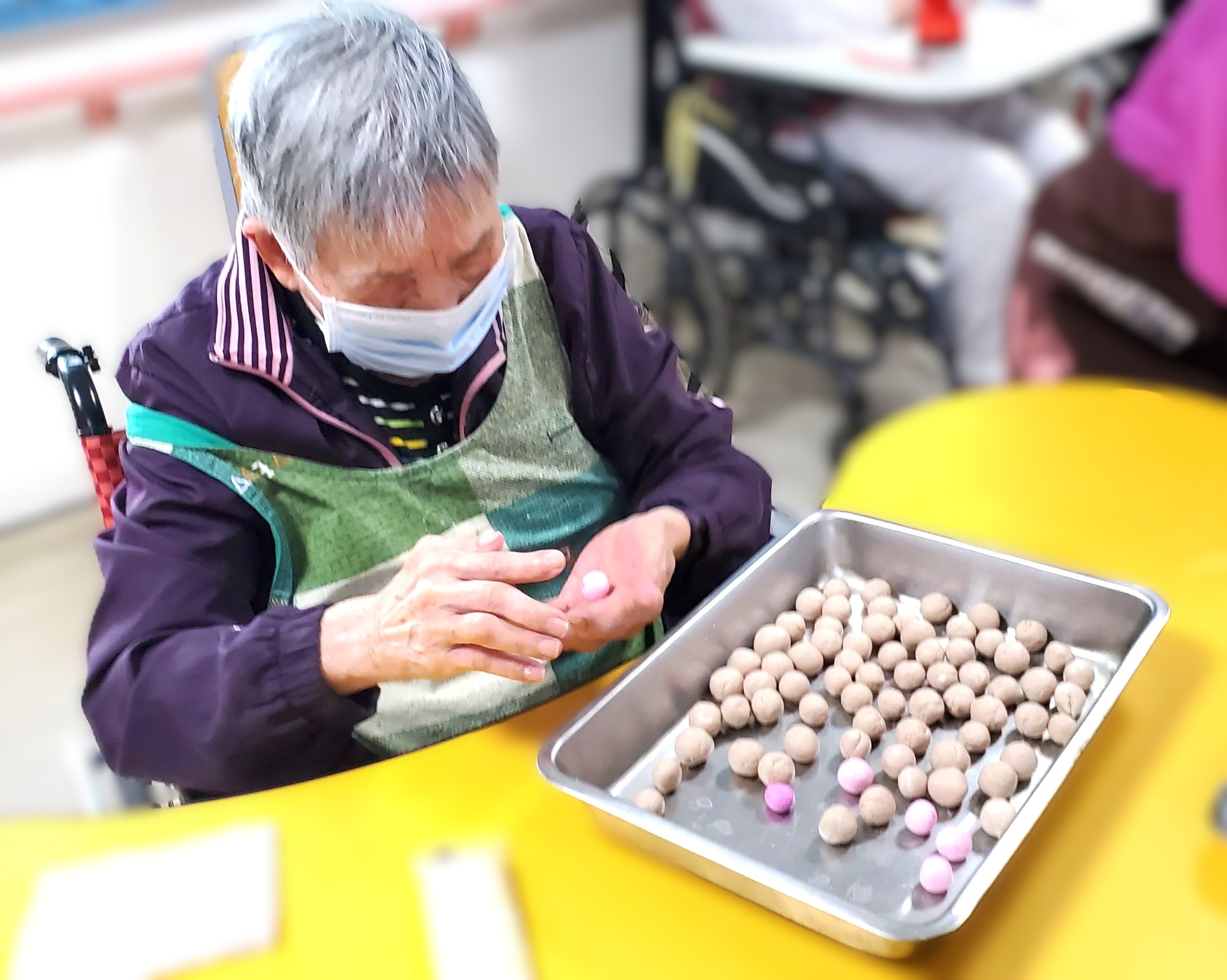松柏園護理之家長輩開心搓著五彩湯圓，雙手忙碌、笑意滿溢，手作時光溫馨愉悅。